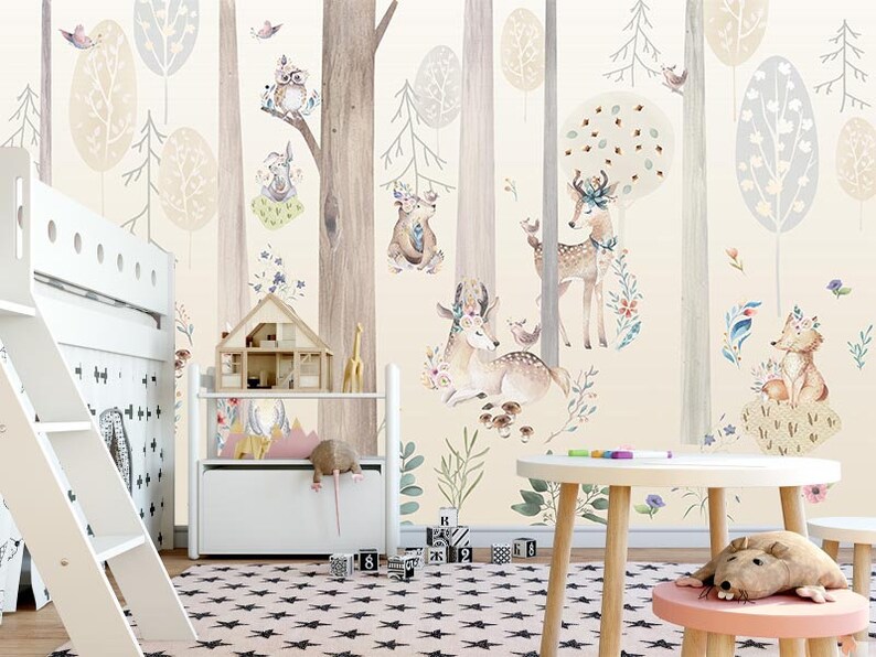 Puede incluir: Una litera de madera blanca con una escalera y un estante de almacenamiento de madera blanca con una casa de mu&ntilde;ecas en la parte superior. La pared detr&aacute;s de los muebles tiene un mural de bosque caprichoso con animales, &aacute;rboles y flores en estilo acuarela.