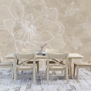 May include: A beige dining room with a white floral wallpaper featuring a large flower and smaller leaves. The room has a wooden table with four chairs.