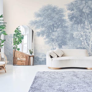 Könnte beinhalten: Ein weißes Sofa mit einer hellblauen und weißen gemusterten Tapete, die eine Waldszene zeigt. Das Sofa steht in einem Wohnzimmer mit einem großen Fenster und einem Korbstuhl.