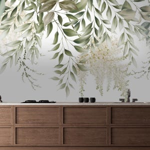 May include: A kitchen scene featuring a wooden countertop and cabinets. The backdrop is a mural of hanging green leaves and white flowers. Kitchen accessories include a cutting board, a coffee maker, and a spice rack.