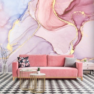 May include: A pink and purple abstract wall mural with gold accents. The mural is in a living room setting with a pink sofa, two gold end tables, and a black and white checkered floor.