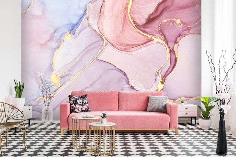 May include: A pink and purple abstract wall mural with gold accents. The mural is in a living room setting with a pink sofa, two gold end tables, and a black and white checkered floor.