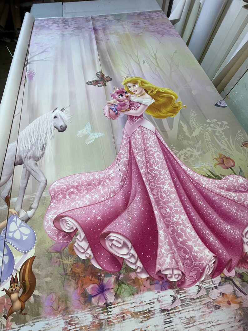 May include: A pink and white princess dress with a white unicorn and a small pink bird in the background. The dress has a sparkly design and a flowing skirt.