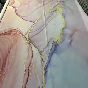 May include: A pink and purple abstract background with gold accents. The background has a marbled look with swirls and lines.