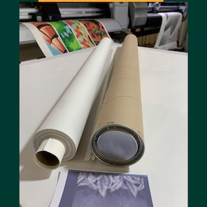 Op de afbeelding: Een witte canvas print opgerold en klaar om te worden verzonden in een bruine kartonnen buis. De print heeft een tropisch bladontwerp.