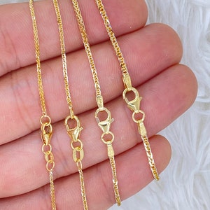 May include: Four gold chains of different lengths, all with a box clasp. The chains are arranged in order of length, with the shortest chain on the left and the longest chain on the right.