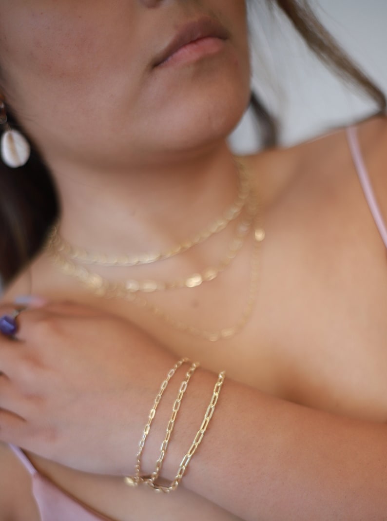 Pu&ograve; includere: Un braccialetto a catena d'oro con tre catene collegate. Il braccialetto &egrave; realizzato con una catena sottile e delicata.