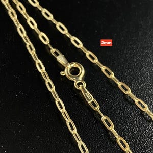 May include: A gold chain necklace featuring elongated oval links with a spring ring clasp. The metal is stamped 10KT and the chain width is labeled as 2mm. The design consists of a continuous series of connected gold loops forming a delicate chain.