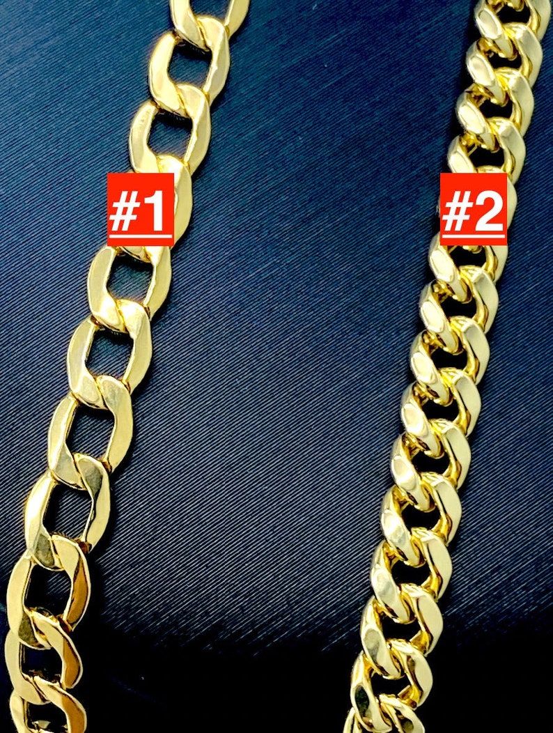 May include: Two gold chains, one labeled #1 and the other #2, are shown against a dark blue background. The chains are both curb chains, but the chain labeled #1 has larger links than the chain labeled #2.
