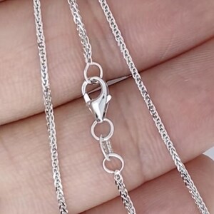 May include: A silver chain necklace with a lobster clasp. The chain is a delicate, braided design.