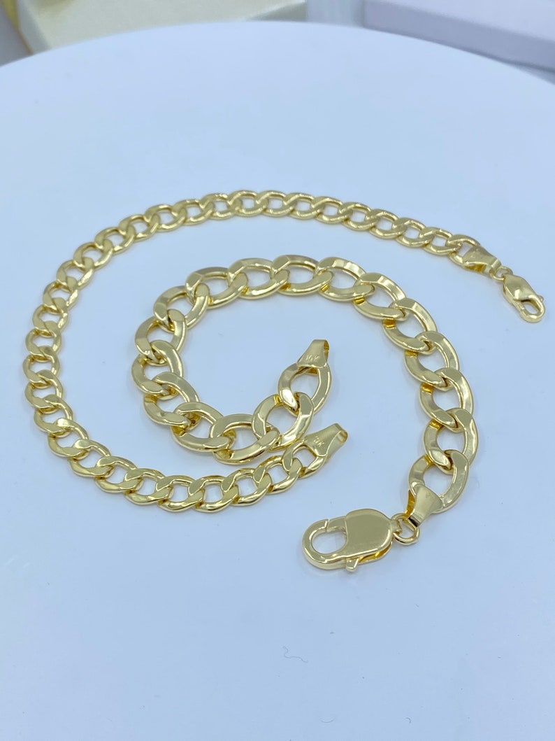 May include: A gold chain necklace and bracelet set with a curb link design.