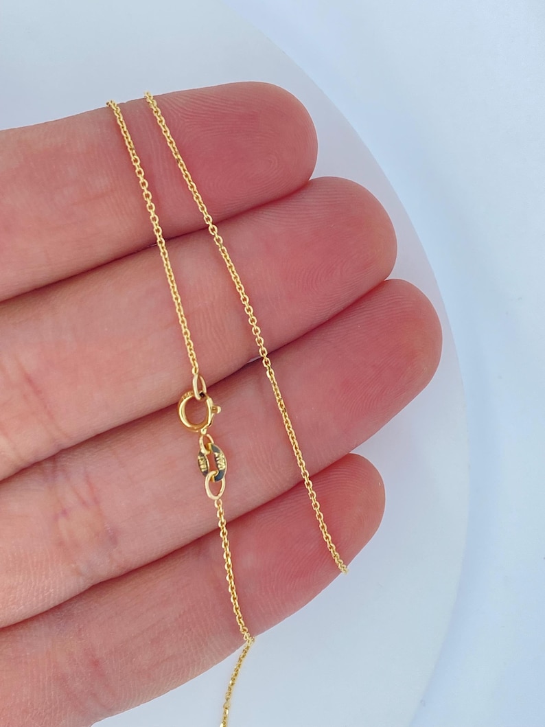 May include: A gold chain necklace with a lobster clasp.