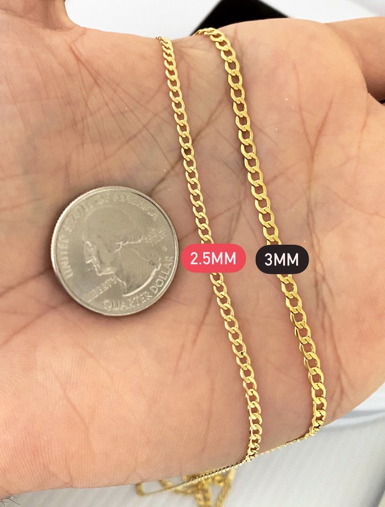May include: Two gold chains, one 2.5mm and one 3mm thick, are laid out on a hand for comparison. The chains are both Cuban link style.
