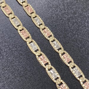 Puede incluir: Un collar de cadena de oro con un dise&ntilde;o tricolor. La cadena est&aacute; hecha de oro amarillo, blanco y rosa. Los eslabones son de forma ovalada y tienen un patr&oacute;n de corte de diamante.