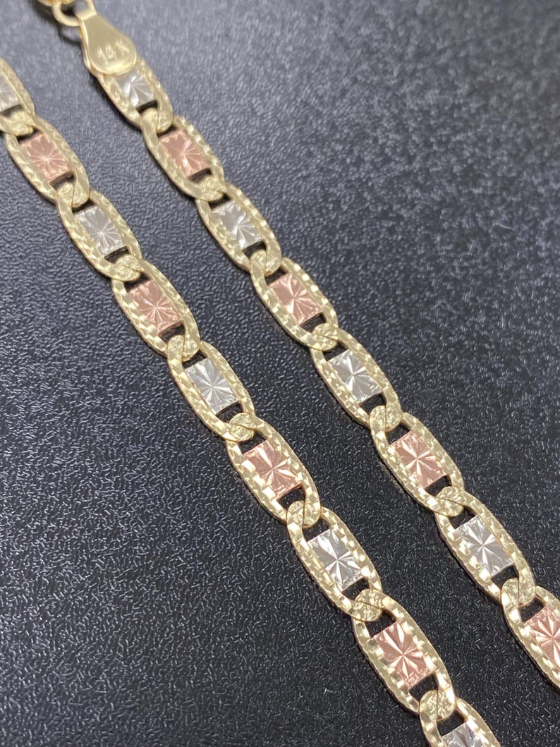 Puede incluir: Un collar de cadena de oro con un dise&ntilde;o tricolor. La cadena est&aacute; hecha de oro amarillo, blanco y rosa. Los eslabones son de forma ovalada y tienen un patr&oacute;n de corte de diamante.