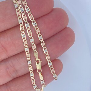K&ouml;nnte beinhalten: Eine goldene Halskette mit filigranem Kettendesign. Die Kette hat abwechselnd Glieder aus Gelb-, Wei&szlig;- und Ros&eacute;gold. Die Halskette wird mit einem Karabinerverschluss gesichert. Die Kette ist etwa 45 cm lang.