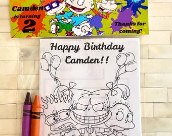 May include: A birthday-themed coloring book set featuring cartoon characters, a banner that reads "Camden is turning 2", and two crayons. The coloring book says "Happy Birthday Camden!!" with balloons and a cake.