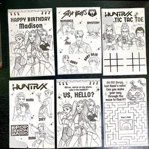 May include: A collection of white cards with black line art illustrations. The cards feature various designs, including portraits, text, and a tic-tac-toe game. Some cards have text like "HAPPY BIRTHDAY Madison" and "US, HELLO?"