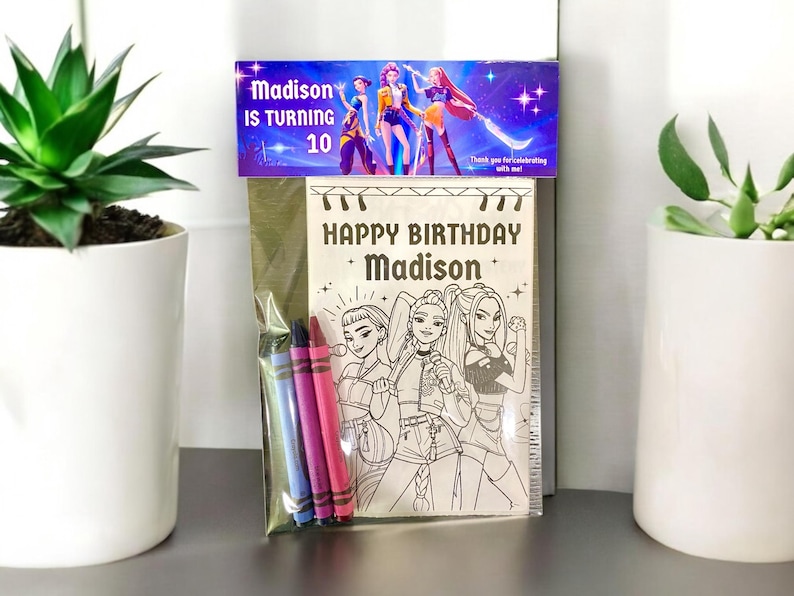 May include: A birthday coloring book set with a purple and blue banner that reads "Madison is turning 10." The coloring book has a black and white illustration of three girls and the words "Happy Birthday Madison."