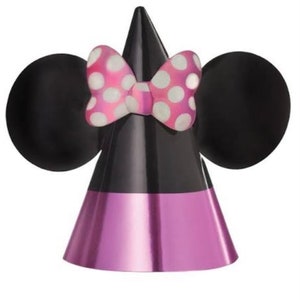 Puede incluir: Un gorro de fiesta negro y rosa con orejas de Minnie Mouse y un lazo rosa con lunares blancos. El gorro est&aacute; hecho de papel brillante.