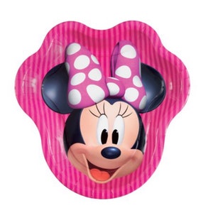 Puede incluir: Plato de papel rosa con una imagen de dibujos animados de Minnie Mouse. Minnie Mouse lleva un lazo rosa con lunares blancos y tiene un fondo a rayas rosa y blanco.