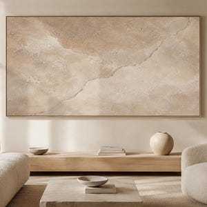 Könnte beinhalten: Ein großes, rechteckiges Wandbild mit einer strukturierten Impasto-Oberfläche in Beige-, Creme- und hellen Brauntönen. Das Kunstwerk zeigt ein dezentes, diagonal verlaufendes rissartiges Muster in der Mitte, das eine geschichtete, organische Optik erzeugt.