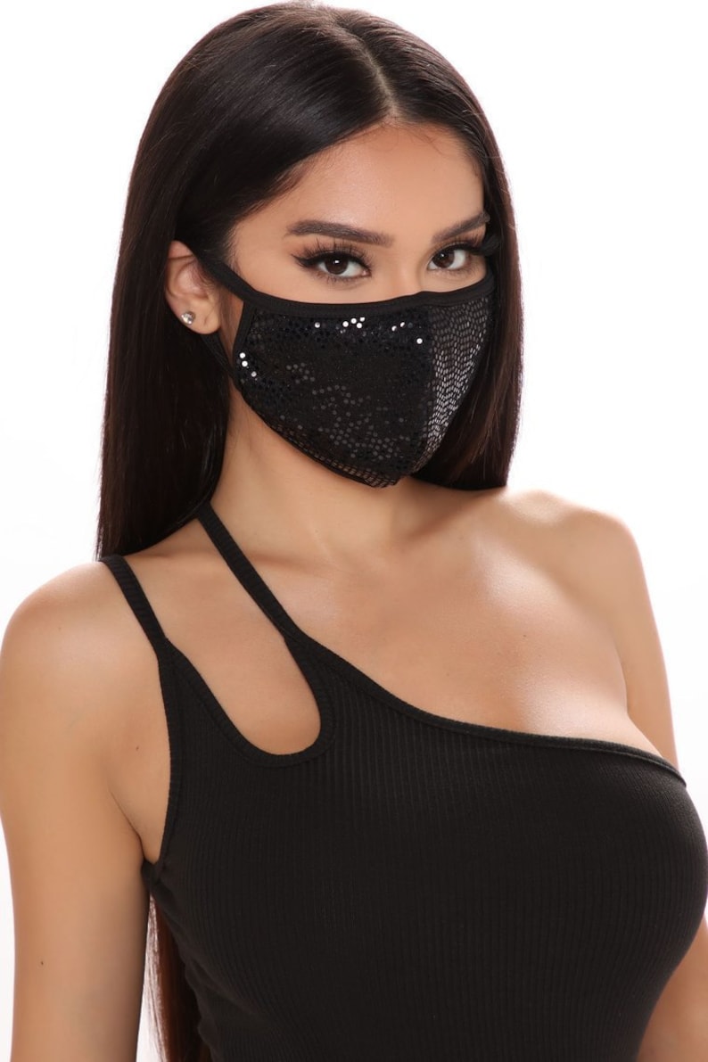 Woman wearing a black sequin face mask with black top.