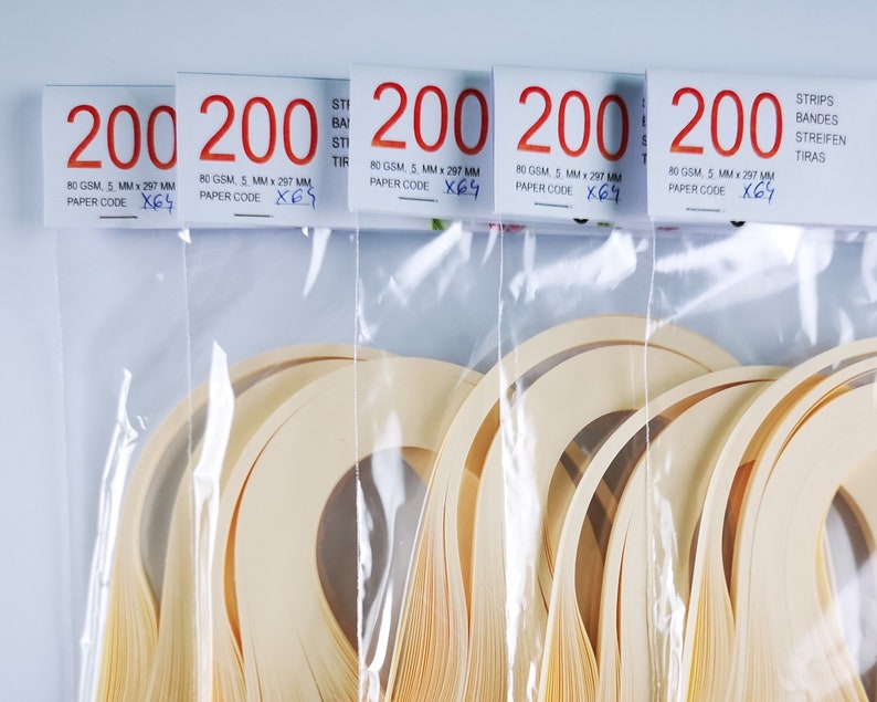 May include: Five packages of 200 cream-colored paper strips, each package labeled "200" and "80 GSM, 5 MM x 297 MM, PAPER CODE X64 or X67". The strips are packaged in clear plastic bags.