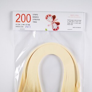 May include: A package of 200 quilling strips in cream color. The package is labeled with the text "200", "80 GSM, 5 MM x 297 MM", "PAPER CODE X65", "STRIPS", "BANDES", "STREIFEN", "TIRAS", "QUILLING", "FUN AND EDUCATION", "Roll the paper, stick and shape it, make light of loose coils, shape them in funny ways, HAVE FUN!", and "MADE IN ROMANIA".