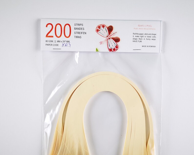 May include: A package of 200 quilling strips in cream color. The package is labeled with the text "200", "80 GSM, 5 MM x 297 MM", "PAPER CODE X65", "STRIPS", "BANDES", "STREIFEN", "TIRAS", "QUILLING", "FUN AND EDUCATION", "Roll the paper, stick and shape it, make light of loose coils, shape them in funny ways, HAVE FUN!", and "MADE IN ROMANIA".