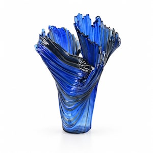 Può includere: Un vaso in vetro alto e svasato caratterizzato da una palette di colori blu cobalto vibrante e nero traslucido. La superficie presenta profonde creste verticali e pieghe ondulate che creano un aspetto dinamico e strutturato.