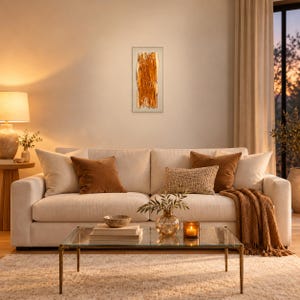Amber fused glass wall art above a woven-front cabinet, beside a ceramic vase and dried stems, with soft sunlight highlighting the glass in a warm bohemian interior.