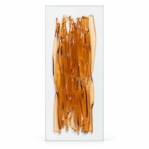 Amber fused glass wall art by JG Glass Art, shown upright against a white background, with flowing translucent glass ribbons layered over a clear rectangular base.