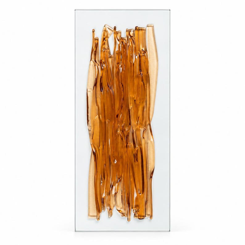 Amber fused glass wall art by JG Glass Art, shown upright against a white background, with flowing translucent glass ribbons layered over a clear rectangular base.