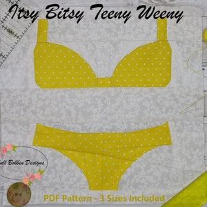 Op de afbeelding: Een stoffen blok met een gele bikini met witte stippen op een witte bloemenachtergrond. De tekst "Itsy Bitsy Teeny Weeny" staat bovenaan en "PDF Pattern - 3 Sizes Included" onderaan. Een naaiproject.