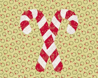 May include: Two crossed candy canes with red and white stripes and festive patterns. The candy canes are set against a light yellow background with a repeating pattern of small wreaths, creating a holiday theme.