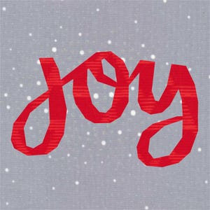 Può includere: Un tessuto quadrato grigio con un motivo di piccoli puntini bianchi. La parola "joy" è scritta in grandi lettere rosse al centro. Le lettere hanno un aspetto leggermente strutturato e il design generale evoca un tema festivo e natalizio.