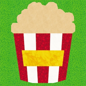 Peut inclure: Un seau de popcorn rayé rouge et blanc avec une étiquette jaune. Le seau est rempli de popcorn et est posé sur un fond vert.
