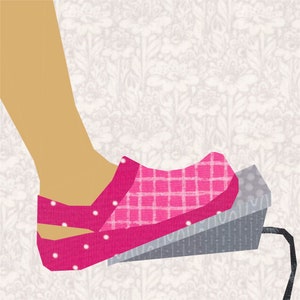 May include: A pink and white polka dot and checkered patterned foot pedal with a grey base. The pedal is being pressed down by a foot.
