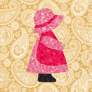 Może przedstawiać: Aplikacja przedstawiająca dziewczynkę w różowym kapeluszu i sukience, wykonaną z różowego i czerwonego materiału. Dziewczynka stoi na tle żółtego i białego wzoru paisley.