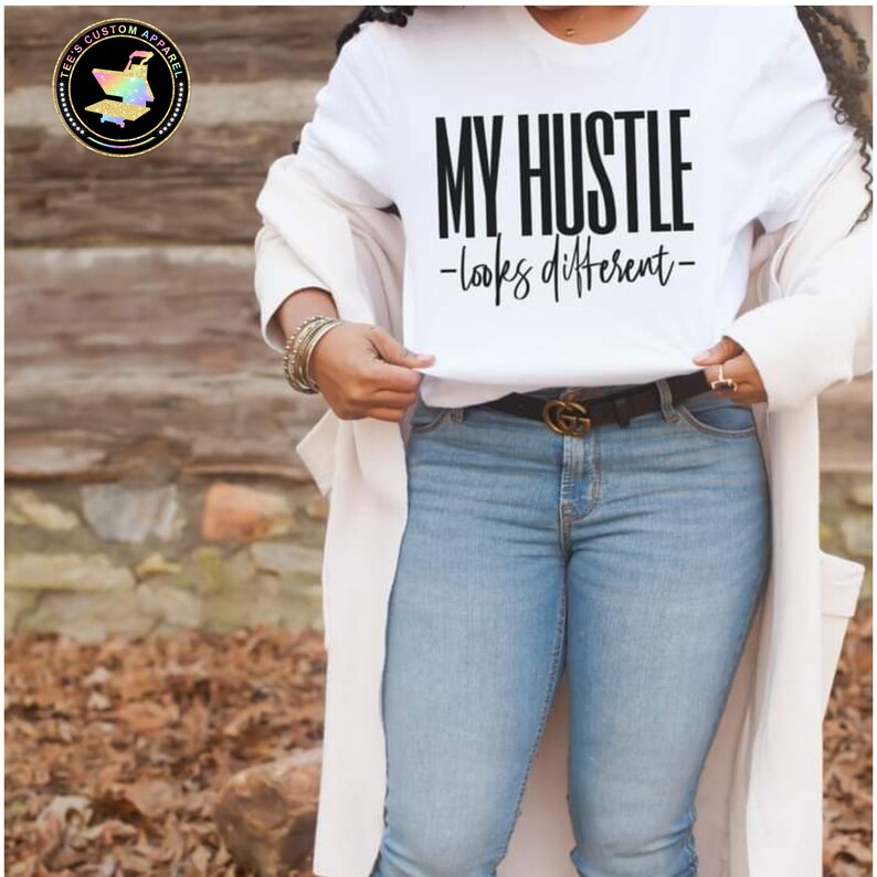 May include: A white t-shirt with the text "MY HUSTLE -looks different- " printed in black.