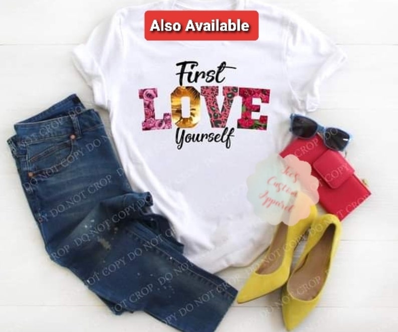 May include: White t-shirt with the text "First Love Yourself" in black and pink letters. The word "Love" is decorated with floral and animal print designs.