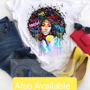 May include: White t-shirt with a colorful graphic of a woman with an afro hairstyle. The graphic includes colorful paint splatters and the words "Dream" and "108".