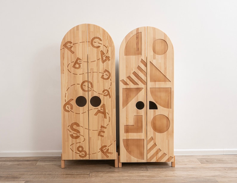 May include: Two wooden cabinets with arched tops and doors. The cabinet on the left has a design of letters and numbers carved into the doors. The cabinet on the right has a design of geometric shapes carved into the doors.