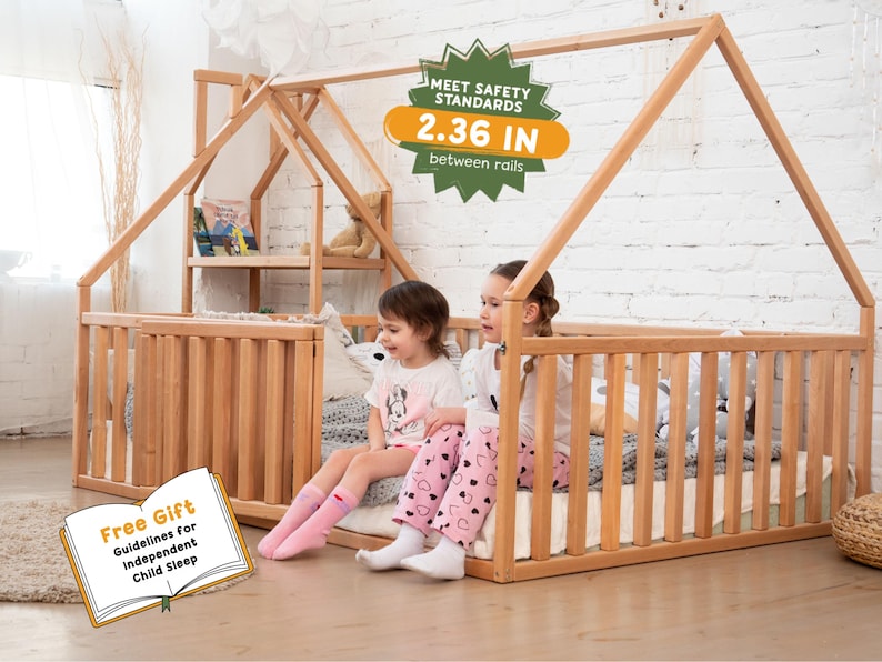 May include: A natural wood-toned house-shaped bed frame with vertical slats and a shelf. The image includes the text "MEET SAFETY STANDARDS 2.36 IN between rails" and two children sitting on the bed. A book with the text "Free Gift Guidelines for Independent Child Sleep" is also visible.