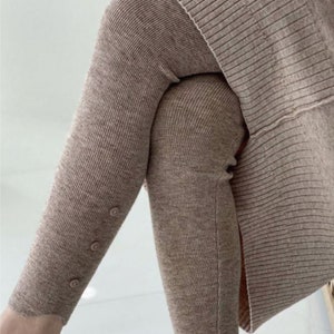Peut inclure: Gros plan sur un legging en tricot c&ocirc;tel&eacute; marron avec trois petits boutons sur le c&ocirc;t&eacute; de la jambe. Le legging fait partie d'un ensemble assorti, avec un haut coordonn&eacute; visible sur l'image.
