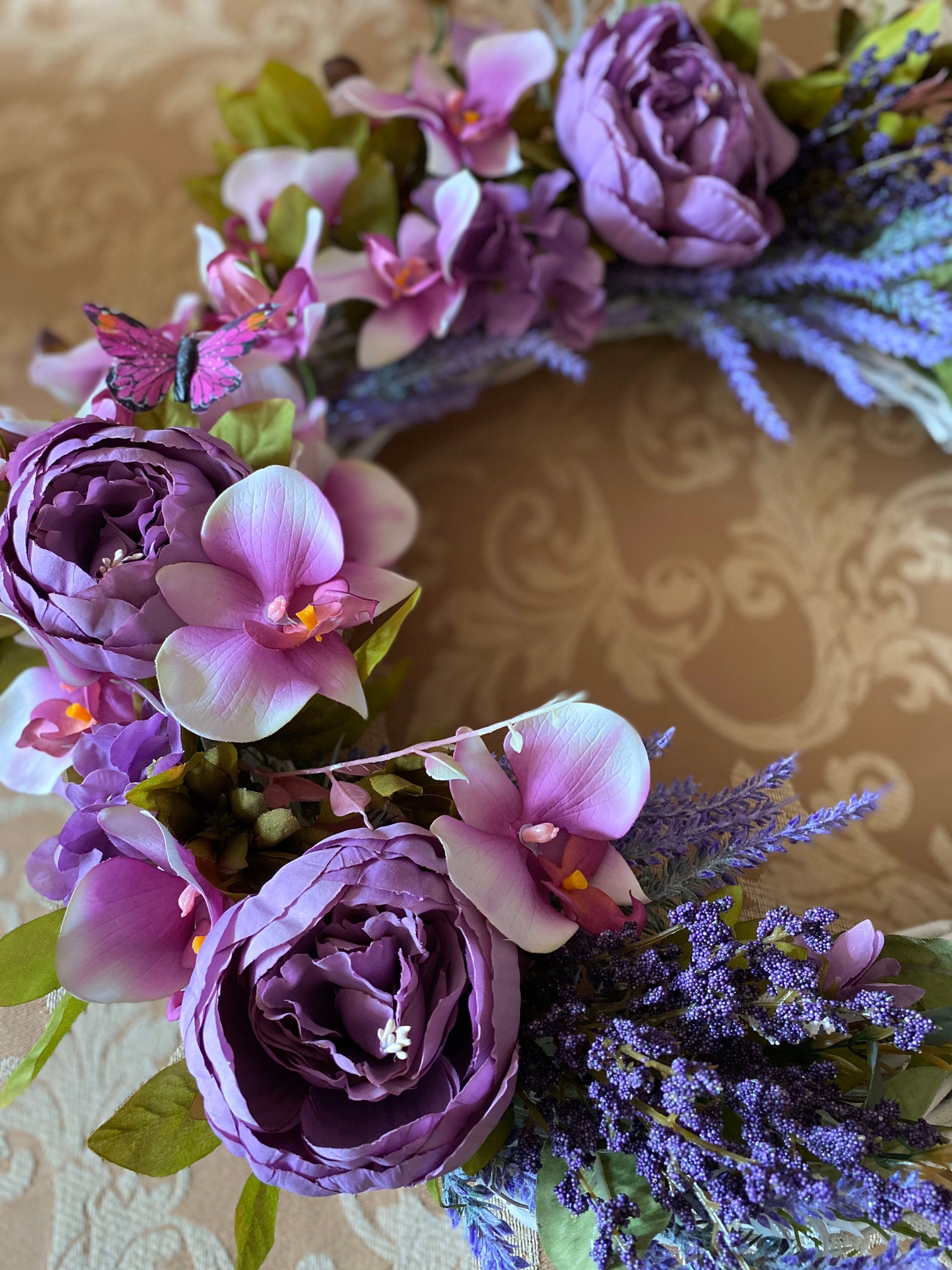 A silk flower door wreath with purple flowers. Etsy