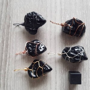 May include: Six black obsidian stones wrapped in wire, each with a different wire colour, and a small black obsidian stone.