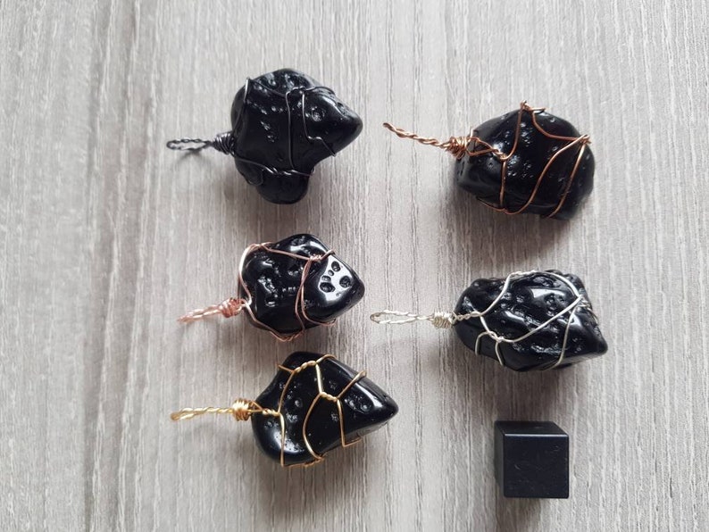 May include: Six black obsidian stones wrapped in wire, each with a different wire colour, and a small black obsidian stone.