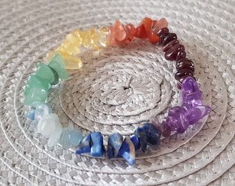Op de afbeelding: Een regenboog chakra armband gemaakt van natuurlijke stenen. De armband heeft zeven verschillende gekleurde stenen, waaronder rood, oranje, geel, groen, blauw, indigo en violet.